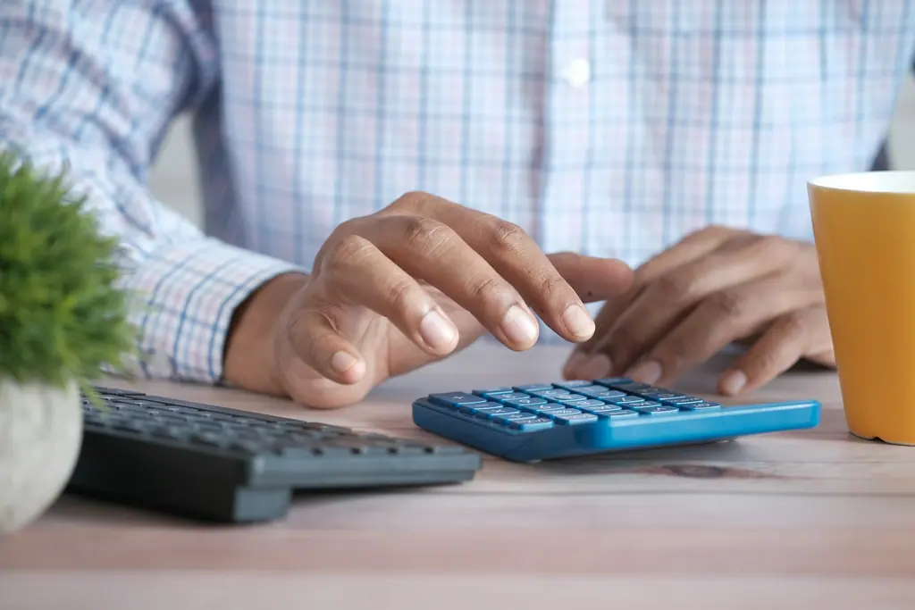 A professional reviewing accounting paperwork at a desk, used as context imagery.