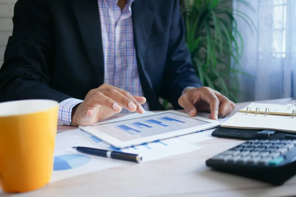 Printed financial reports with summary tables, used as context imagery.