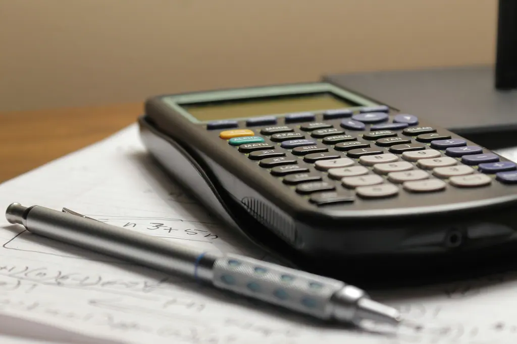Calculator resting on accounting worksheets, used as context imagery.