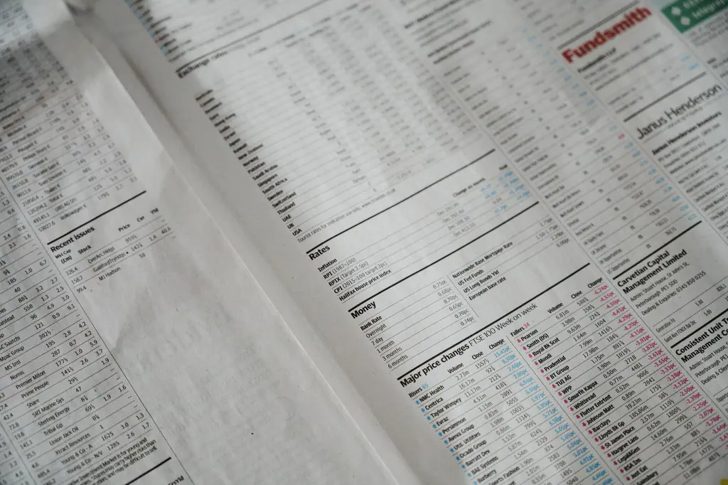 Business finance charts and reports spread across a meeting table, used as context imagery.